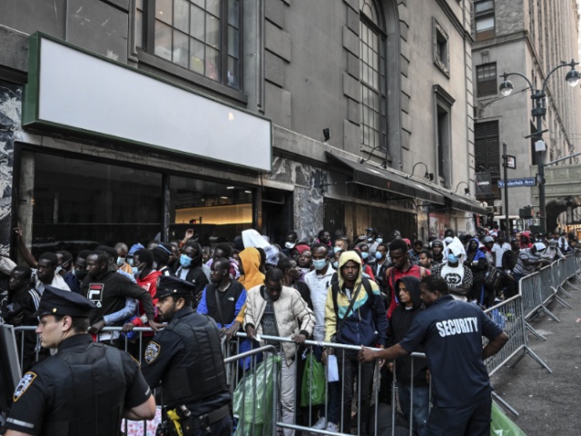 NEW YORK, US - AUGUST 02: Police officers take security measures during migrants line up outside Roosevelt Hotel while waiting for placement inside a shelter as asylum seekers camp outside the hotel after the Manhattan relief center is at full capacity in New York, United States on August 02, 2023. Since last spring, New York City has experienced a staggering influx of tens of thousands of asylum seekers. In response to the surge in migration, the city has established more than 160 sites to accommodate and assist these individuals. New York Mayor Eric Adams stated in early June that the city takes on important responsibilities by providing shelter, food, clothing and other essential services to incoming asylum seekers. (Photo by Fatih Aktas/Anadolu Agency via Getty Images)
