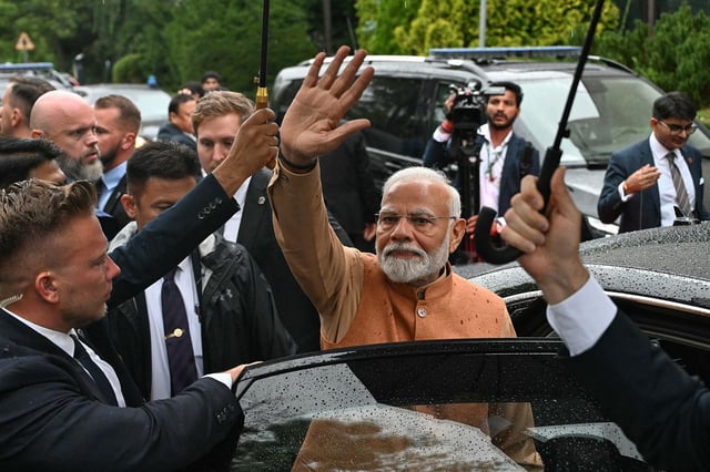 Indian Prime Minister Narendra Modi waves after visiting a memorial in Warsaw, Poland on August 21.