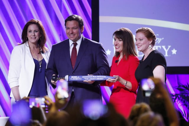 Two of Moms for Liberty's co-founders pose with Florida Gov. Ron DeSantis in 2022. (Photo by Octavio Jones/Getty Images)