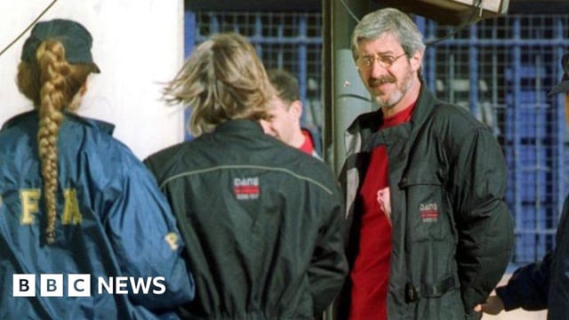Leonardo Bertulazzi (R), an alleged former chief of the Italian militant group Red Brigade, is escorted by Argentine police after his arrest 4 November, 2002 in Buenos Aires)