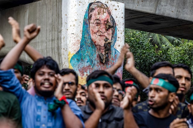 Students chant slogans near a vandalised mural of Bangladesh's ousted Prime Minister Sheikh Hasina, during a protest demanding accountability and trial against Hasina, near Dhaka University in the capital on August 12, 2024.