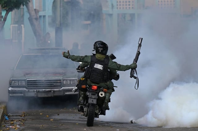 Members of the National Guard riot squad throw tear gas canisters at Chacao neighbourhood in Caracas. Photo: AFP