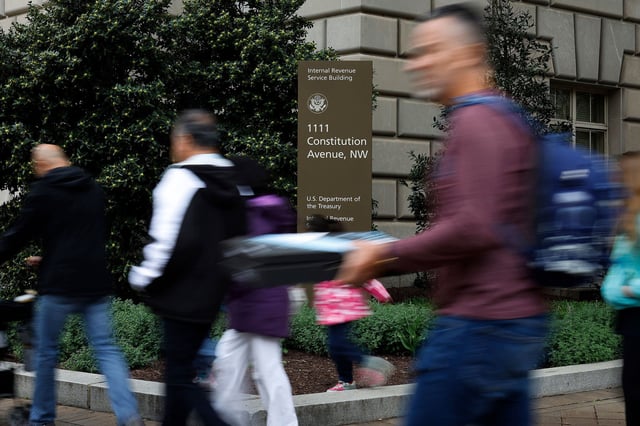 Tourists walk past the headquarters of the Internal Revenue Service near the National Mall on April 07, 2023 in Washington, DC.