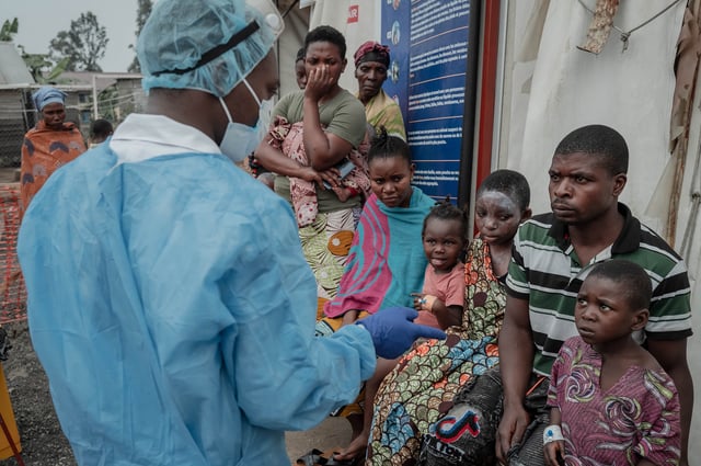 Patients listen to a doctor outside the consultation room of the Mpox treatment centre at Nyiragongo General Referral Hospital, north of Goma on Aug. 17, 2024. 