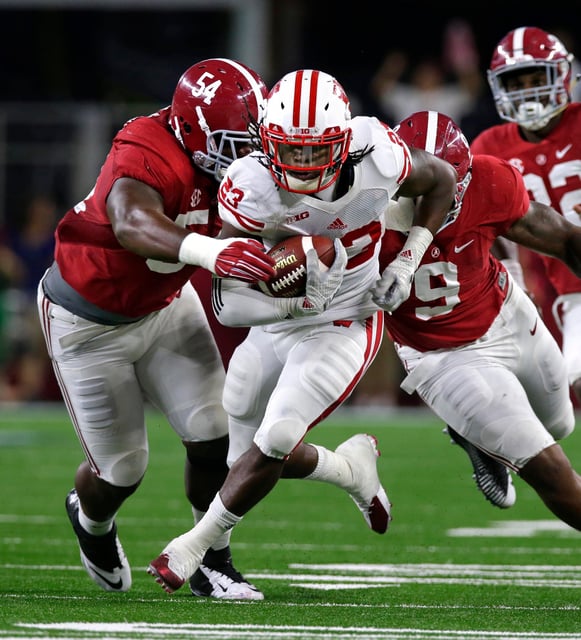 Wisconsin Badgers running back Dare Ogunbowale (23) gains yardage against Alabama Crimson Tide defensive lineman Dalvin Tomlinson (54) and Alabama Crimson Tide defensive lineman Da'Shawn Hand (9) during Wisconsin's 35-17 loss to Alabama during the football season opener Saturday, September 5, 2015 at AT&T Stadium in Arlington, Texas.