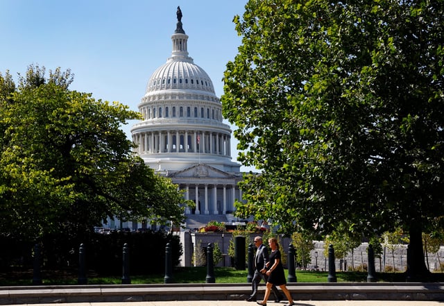 A woman and a man walk in front of the U.S. Capitol in Washington, DC, U.S., September 10, 2024. REUTERS/Piroschka van de Wouw/File 
Photo