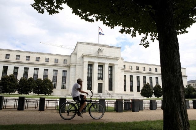 A cyclist passes the Federal Reserve building in Washington, DC, U.S., August 22, 2018. REUTERS/Chris Wattie/File Photo