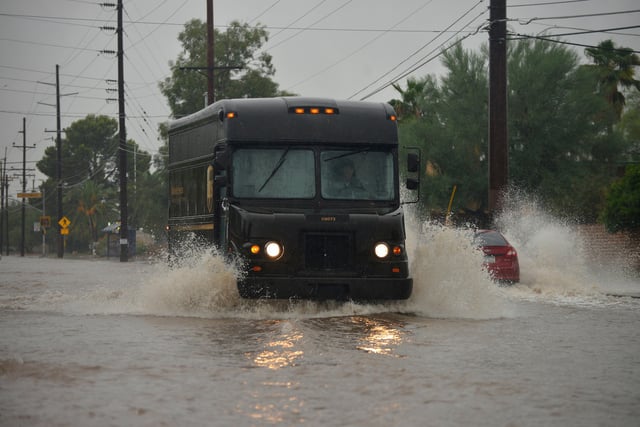 A delivery truck driving through flooded streets during a storm, Sonoran Desert, Arizona, USA. Credit: Norma Jean Gargasz / Alamy Stock Photo.