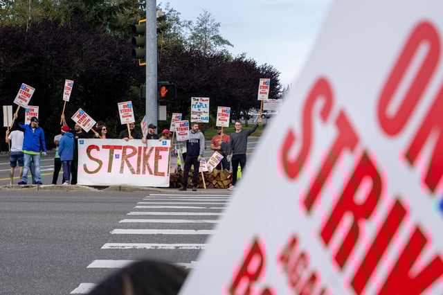 Workers with picket signs outside the Boeing Co. manufacturing facility during a strike in Everett, Washington, US, on Friday, Sept. 13, 2024. Boeing Co. factory workers walked off the job for the first time in 16 years, halting manufacturing across the planemaker's Seattle hub after members of its largest union voted overwhelmingly to reject a contract offer and go on strike.