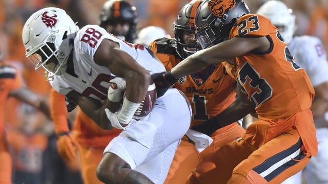 FILE - Oregon State's Ryan Cooper Jr. (23) attempts to strip the ball from Washington State's De'Zhaun Stribling (88) while Oregon State's Omar Speights (1) assists on the tackle during the first half of an NCAA college football game Saturday, Oct. 15, 2022, in Corvallis, Ore. Oregon State and Washington State are the last remaining members of the Pac-12 after this season and they have been fielding calls from the likes of the Mountain West and American Athletic conferences eager to discuss options. (AP Photo/Mark Ylen, File)
