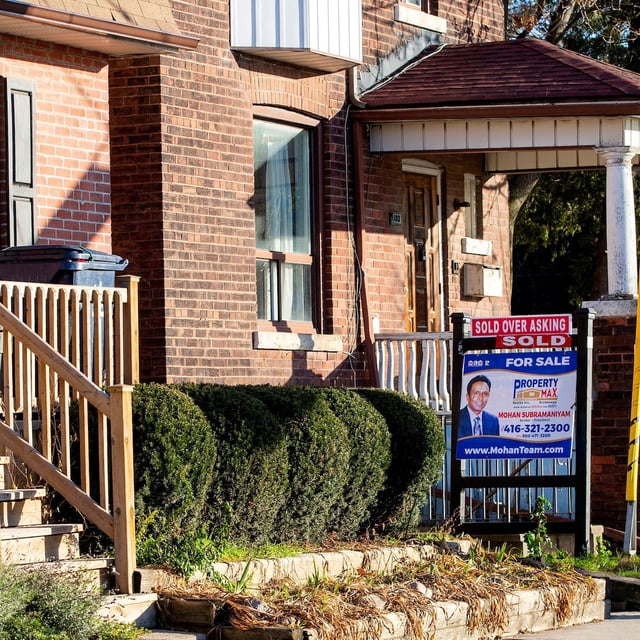 FILE PHOTO: A for sale sign is displayed outside a home in Toronto, Ontario in Toronto, Ontario, Canada December 13, 2021.  REUTERS/Carlos Osorio/File Photo