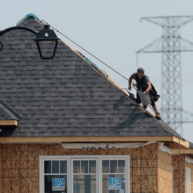 A construction worker shingles the roof of a new home in a housing development in Ottawa on Monday, July 6, 2015. Statistics Canada is set to release its August labour force survey this morning. THE CANADIAN PRESS/Sean Kilpatrick