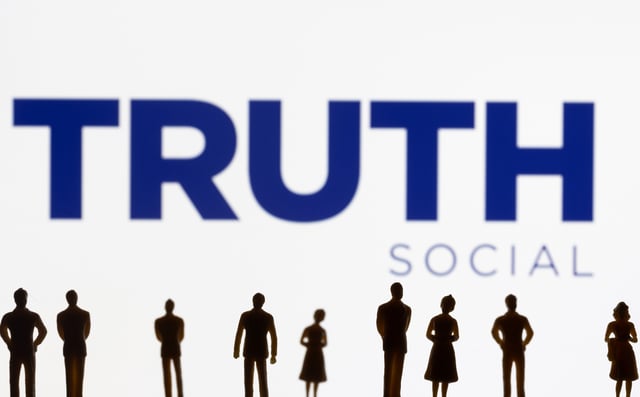 The Truth social network logo is seen displayed behind figurines in this picture illustration taken February 21, 2022. REUTERS/Dado Ruvic/Illustration/File Photo