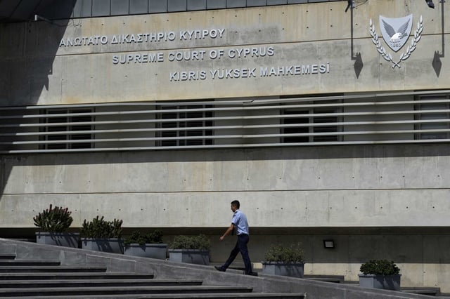 A Cypriot police officer walks outside from the Cyprus' Supreme Court in Nicosia, Cyprus, on Wednesday, Sept. 18, 2024, as Cyprus’ top court has ordered that the government's comptroller general be removed from his post for alleged misconduct.