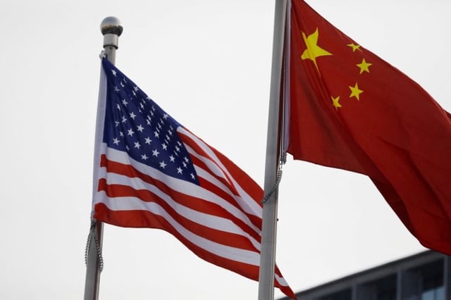 Chinese and U.S. flags flutter outside the building of an American company in Beijing, China January 21, 2021. REUTERS/Tingshu Wang/File Photo