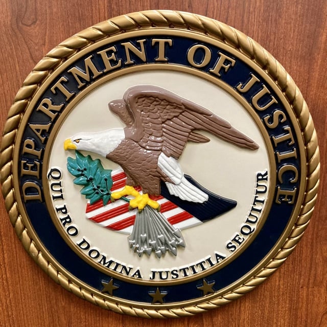 A picture of the Justice Department logo.