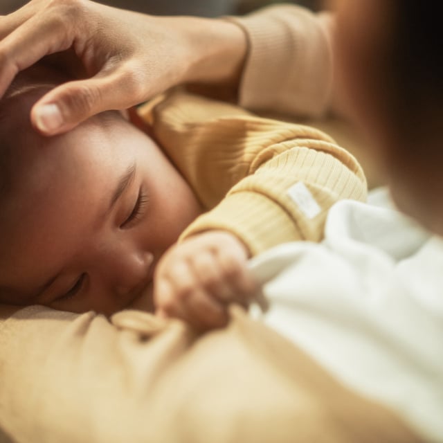 High angle portrait of a cute baby feeding from the breast of her mother. Breastfeeding for longer than three months has been found to be associated with a lower risk of asthma.