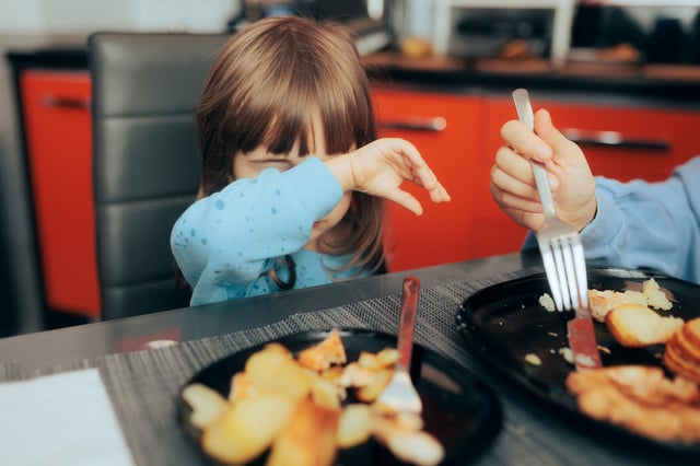 Little child rejecting food option for lunch